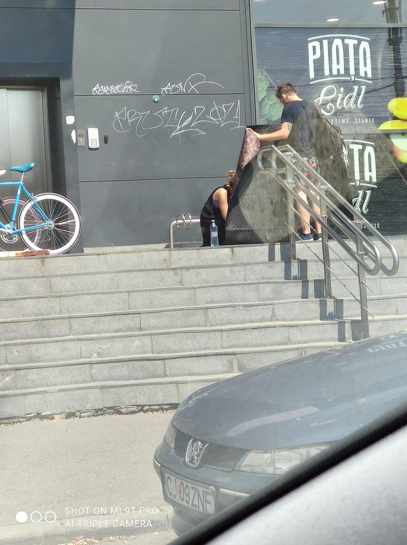 Cățel lăsat în soare în fața unui magazin din Cluj, îngrijit de doi tineri. I-au răcorit și i-au făcut umbră