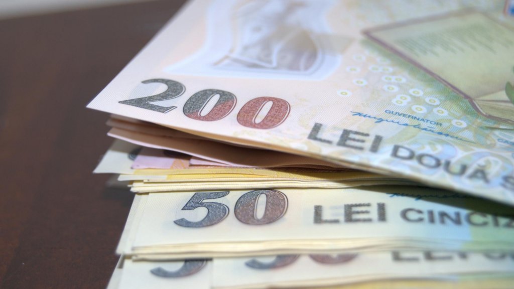 Analiştii financiari estimează o depreciere a leului în următoarele 12 luni şi o majorare a primei de risc a României