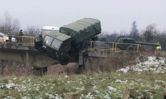 Imagini rupte parcă dintr-un film de acțiune! Camion militar, suspendat pe un pod din Cluj