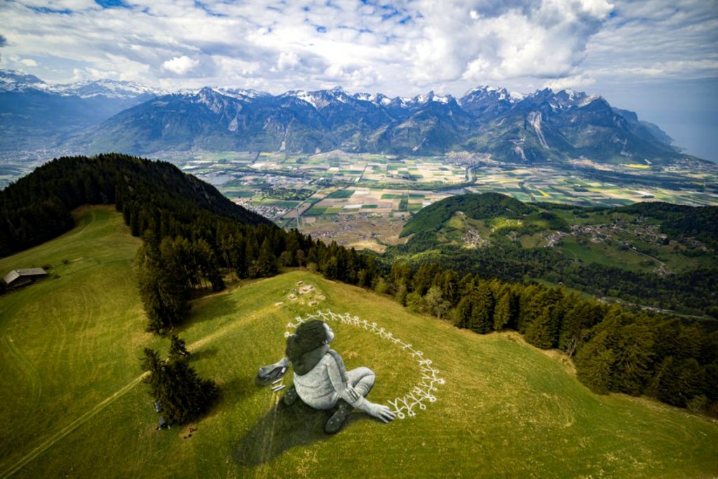 Graffiti de mari dimensiuni realizat pe iarbă. Simbolizează construcţia unei lumi mai solidare şi mai plină de umanitate