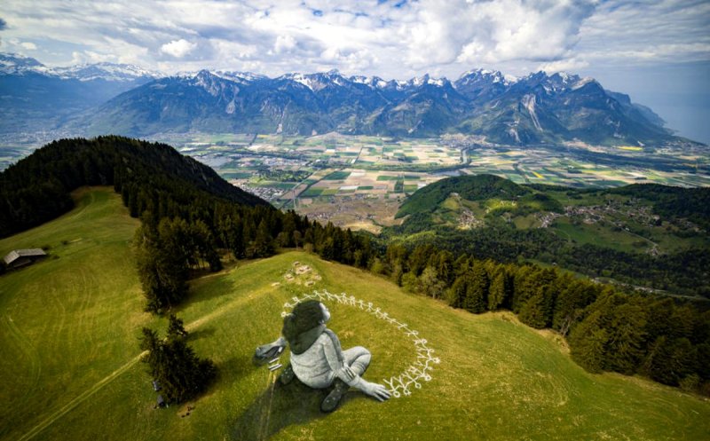 Graffiti de mari dimensiuni realizat pe iarbă. Simbolizează construcţia unei lumi mai solidare şi mai plină de umanitate