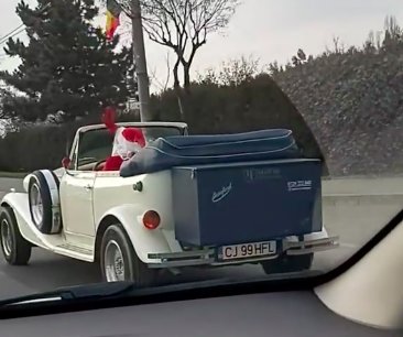 Moș Crăciun se plimbă pe străzile Clujului cu o mașină de epocă