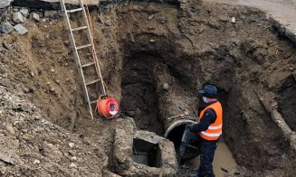 Circulația afectată pe strada Dragalina după inundația de ieri. Muncitorii lucrează pentru remedierea problemei