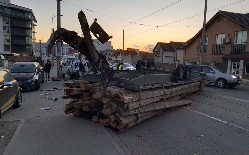 ACCIDENT în Cluj-Napoca: O remorcă plină cu lemne a ajuns cu roțile în sus lovind şi un stâlp de electricitate