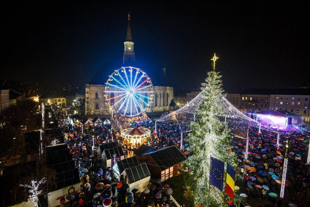 Cum arată Clujul luminat de Crăciun? Târgul a debutat în ploaie. Localnicii de la Voltaj au concertat în deschidere / A pornit și tramvaiul lui Moș Crăciun