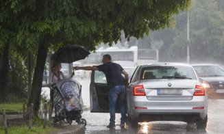 Gest rar de omenie în Cluj: un șofer a oprit mașina și a oferit o umbrelă unei mame și copilului ei surprinși de ploaia torențială
